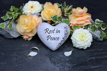 Heart with flowers as a grave decoration with a farewell greeting Rest in Peace.