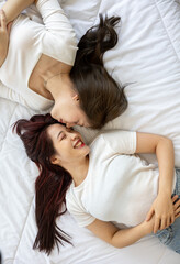 Obraz na płótnie Canvas Warm and Intimate Moment: Young Asian Lesbian Partners Sharing Love and Happiness Together on the bed at Home 