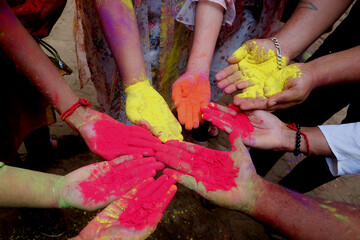 Close-up partial view of  colorful powder in hands at holi festival