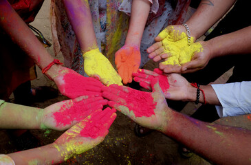 Close-up partial view of  colorful powder in hands at holi festival
