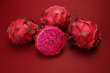 Ruby red exotic cactus dragon fruit whole cut half on red background - 768483586