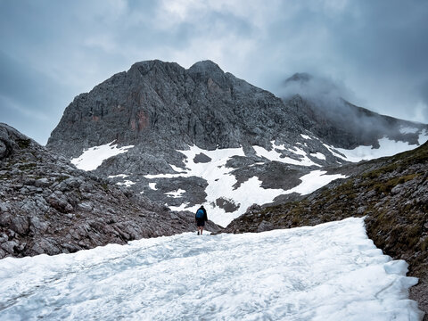 A hike though the Berchtesgaden landscape during summer with rain clouds and remaining snow fields