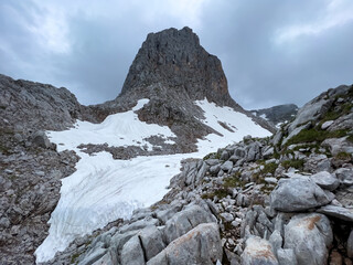 A hike though the Berchtesgaden landscape during summer with rain clouds and remaining snow fields