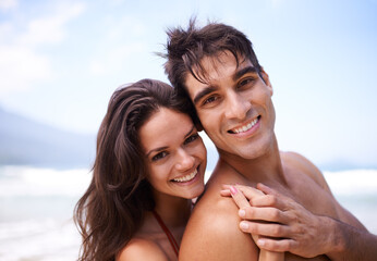 Hug, happy and portrait of couple by beach on vacation, adventure or holiday for romantic travel. Smile, love and young man and woman embracing by ocean for tropical outdoor anniversary weekend trip.