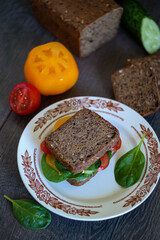 Sandwich with spinach and tomatoes on a plate, a delicious dish