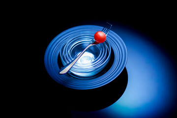 Art of Black Plate with Fork and red Tomato in dark mood photography arts
