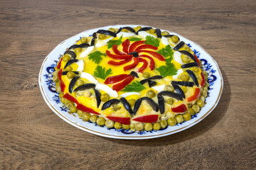 Traditional Romanian boeuf (beef) salad decorated for Christmas or Easter on a wooden table