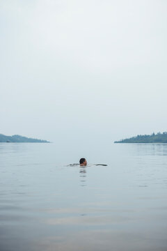 Man swims in peaceful waters of Lake Kivu, Rwanda