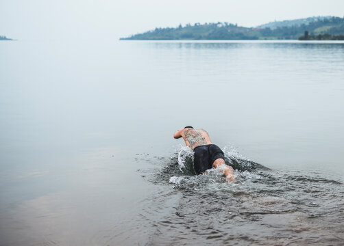 Man with tattoos dives into Lake Kivu, Rwanda