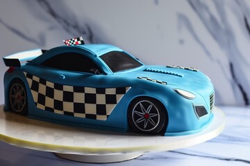 blue racing car cake with checkered flag pattern along the side