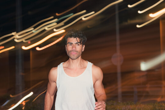 Athletic man jogging in tank top on city street