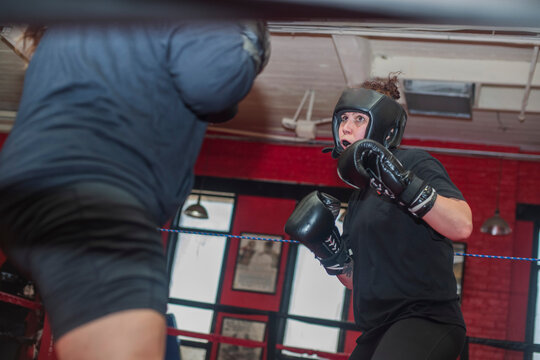 Young Girl sparring with partner in boxing ring