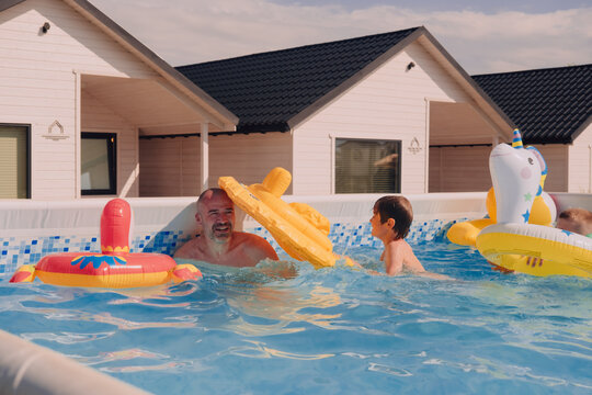 Father and son having fun in a pool
