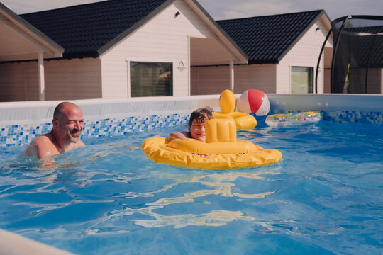 Father and son having fun in a pool