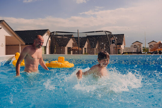 Father and son having fun in a pool