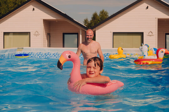 Father and son having fun in a pool