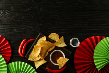 Nachos with tequila and chili pepper on a dark background