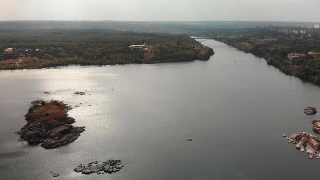 Beautiful view from above of the Khortytsia island in Zaporozhye. Drone view of the Dnieper River and the bridge. Multi-storey buildings, forest. Embankment in Zaporozhye.