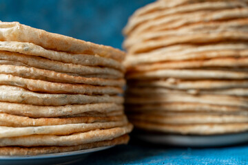 Flatbread lavash, chapati, naan, heap of tortilla on a blue background Homemade flatbread stacked.