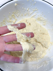 Individual holding raw dough, essential for making staple food