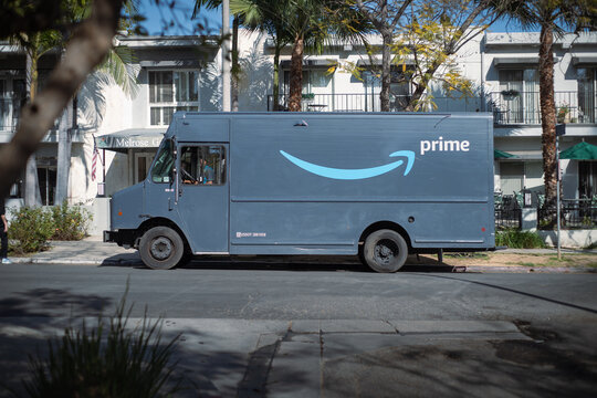 LOS ANGELES, CA - March 26, 2024: Amazon Prime delivery truck delivering packages to a building on a residential street in city of West Hollywood, California
