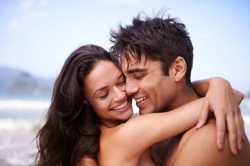 Love, hug and happy couple at beach for tropical holiday adventure, relax and bonding together. Nature, man and woman smile on romantic date with ocean, blue sky and embrace on island vacation.