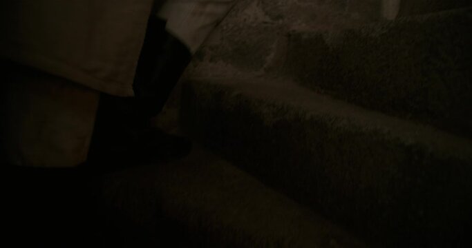 Leather boots of knight running up stone steps of spiral stairs