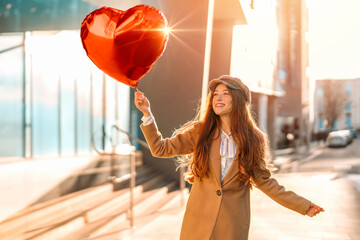 young happy woman with a heart-shaped balloon falling a love, having a fun day, walking around English city Spring is in the air Lifestyle, tourism, valentines day, world woman's day concept