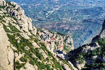 View of Santa Maria de Montserrat Abbey and the surrounding mountains. Montserrat Monastery,...