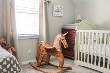 wooden rocking horse in a corner of babys bedroom