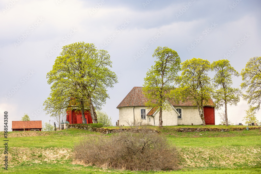 Wall mural Idyllic old church with a red wooden belfry in the swedish countryside