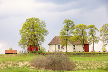 Idyllic old church with a red wooden belfry in the swedish countryside