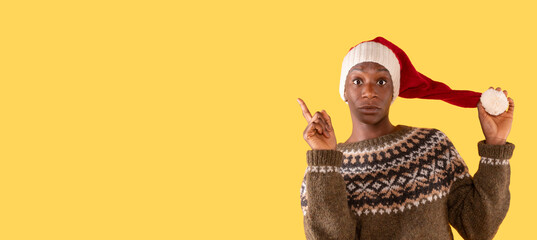 cheerful christmas woman in christmas sweater and santa hat getting thumb up on yellow background....