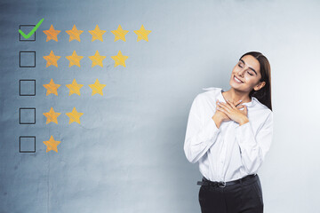 Happy young businesswoman with 5 star rating on concrete wall background. Customer service and...