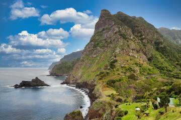 The view of the Madeira coastline, where the vast ocean meets towering cliffs under a sky adorned...