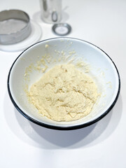 A white dish with a creamy yellow pure on a table
