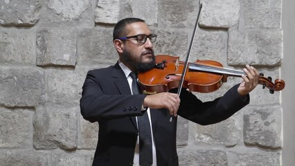Man demonstrating the technique of playing the viola