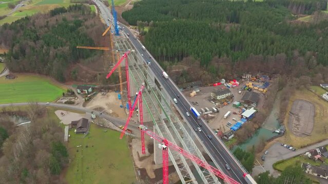 Aerial View Trucks And Cars Driving Through The Bridge Beside The New Bridge Under Construction.