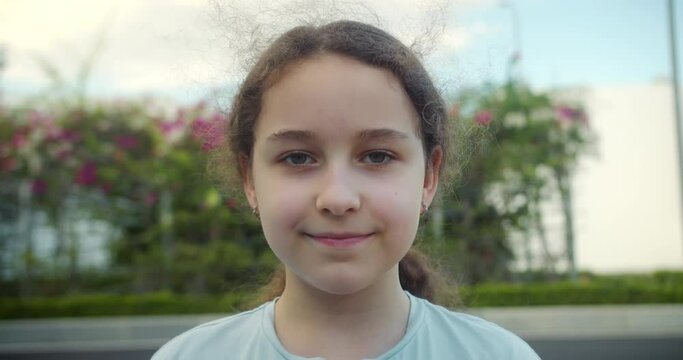 Cute child happy facial expression emotion glad smiling face. Portrait Funny kid little girl smiling child looking at camera in park. Pretty face child. Concept of a happy childhood. 4K