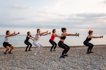 Outdoor yoga and fitness. Side view of group of Caucasian adult fit women are training with...