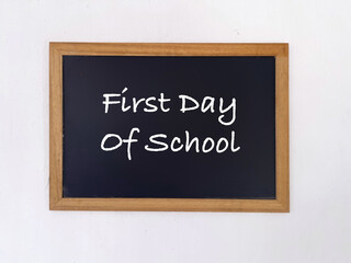 Student and education concept. First Day Of School written on a blackboard. Blurred styled background.