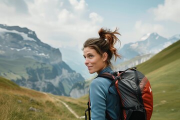 Naklejka premium woman with a backpack hiking in the swiss alps