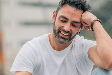 portrait of attractive man with beard outdoors leaning on arm