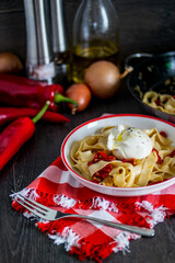 A dish of pasta topped with a poached egg on a table