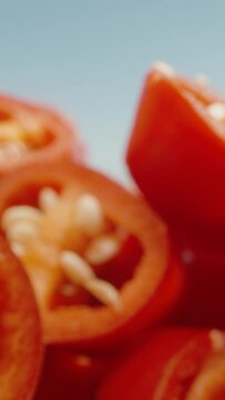 Vertical video.  Sliced red pepper and blue sky. Dolly slider extreme close-up. 