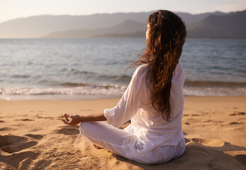 Back view, woman and meditation on beach with lotus pose, mindfulness and zen with fresh air for...