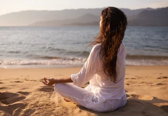  Back view, woman and meditation on beach with lotus pose, mindfulness and zen with fresh air for calm outdoor. Ocean, breeze and travel with yoga for health, peace of mind and holistic healing © peopleimages.com