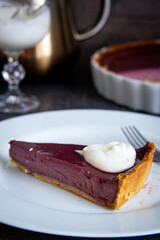 Slice of pie with whipped cream on white plate, a delicious dessert