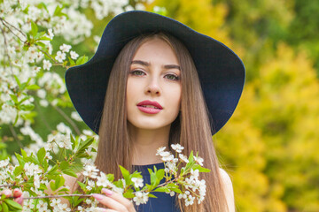 Perfect fashion model with long brown hair and natural makeup against floral background outdoor - 768591350