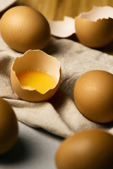 Raw eggs on a woody background  with one broke egg on a drapery